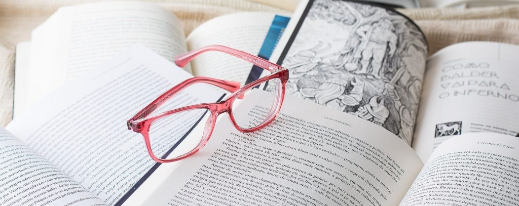 Okulary leżą na otworzonych książkach.