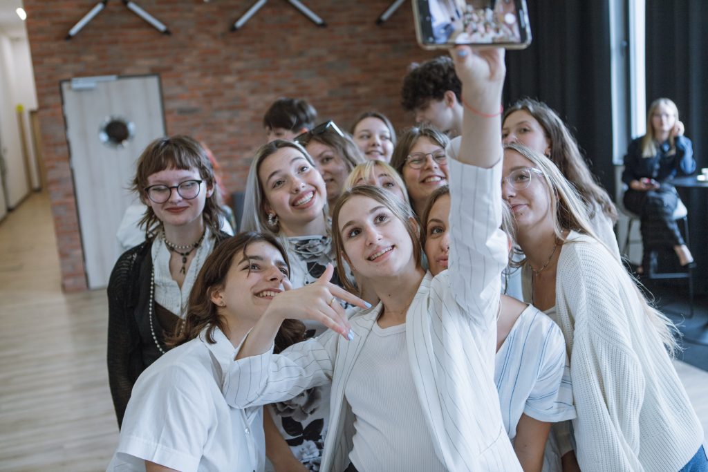 Grupa uśmiechniętych dziewczyn robi sobie selfie.